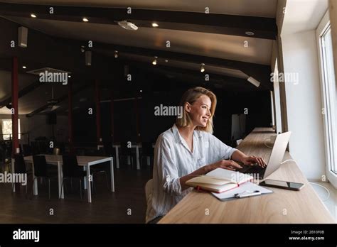 Photo D Une Femme Blonde Souriante Qui Tape Sur Un Ordinateur Portable