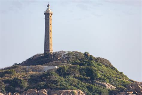 Photograph of a Lighthouse near Trees · Free Stock Photo