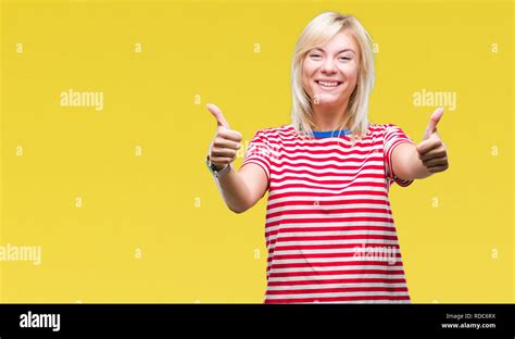 Junge hübsche blonde Frau über isolierte Hintergrund erfolg Zeichen tun positive Geste mit der