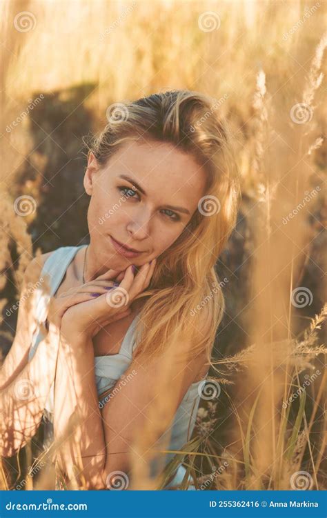 Beautiful Blonde Woman On A Walk In A Field With Dry Grass A Walk In Nature Sunset In A Field