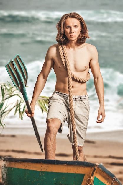 Premium Photo Sexy Man Half Naked Caucasian Long Haired With Oar In Boat On Sand Coast Of