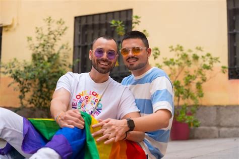 Retrato de casal gay masculino sentado no chão sorrindo na festa do orgulho o conceito lgbt