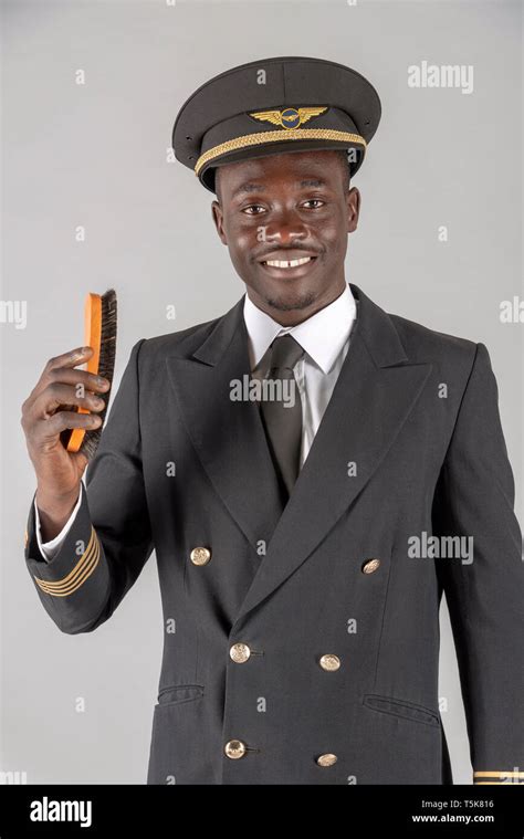 2019. An airline pilot brushing his captain's uniform Stock Photo - Alamy