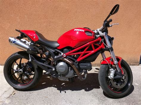 A Red Motorcycle Parked Next To A Tan Wall