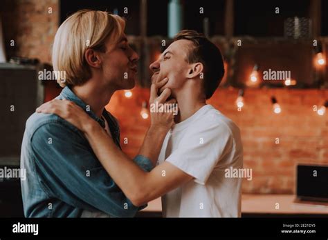 Pareja gay cariñosa en casa Dos hombres guapos abrazando y besando en la cocina Concepto LGBT