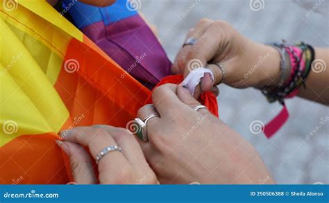 Cierre De Manos Atando Un Nudo A La Bandera Del Orgullo Gay Foto De