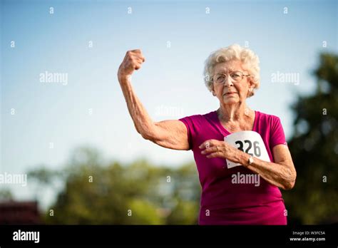 Portrait Of A Strong Senior Woman Flexing Her Arm Muscle Stock Photo