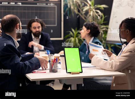 Chief executive officer hosts meeting with his staff next to mockup ...