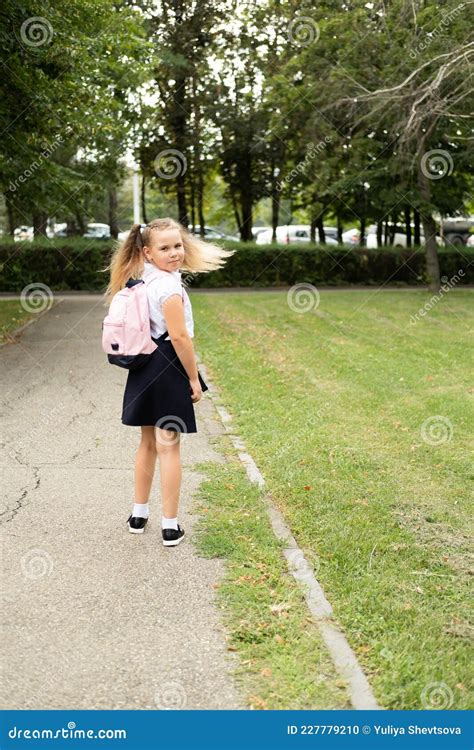écolière Blonde Souriante En Uniforme Scolaire Avec Sac à Dos Rose Allant à L école En Plein Air