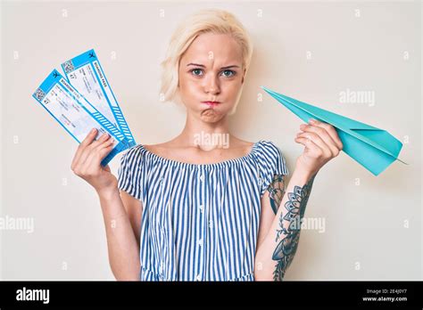 Jeune Femme Blonde Avec Tatouage Tenant Avion En Papier Et Carte D Embarquement Puffant Les