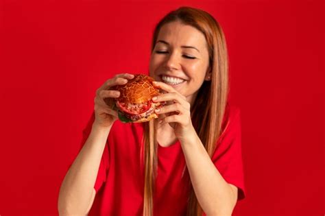 Mujer Joven De Tiro Medio Comiendo Hamburguesa Foto Gratis