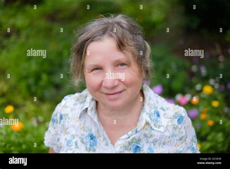 Portrait Of Caucasian Mature Cheerful Mature Woman Standing Outdoors In Garden She Is Smiling
