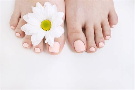 Premium Photo Perfect Nude Pedicure On White Background And Spring Flower Female Feet Top
