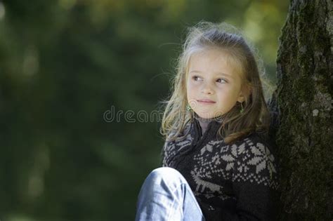 Petite Fille Blonde Assise Contre Un Arbre Photo Stock Image Du Stationnement Adulte