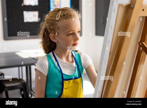 Caucasian Girl With Blonde Hair Focuses On Her Painting In A Classroom In School Stock Photo Alamy