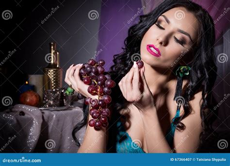 Belle Femme Orientale Sexy Dans La Lingerie Noire De Dentelle Avec De Longs Cheveux Mangeant Des