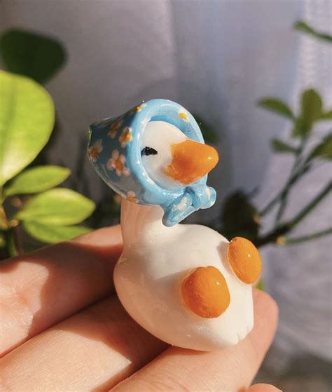 A Small Toy Duck Sitting On Top Of A Person S Hand