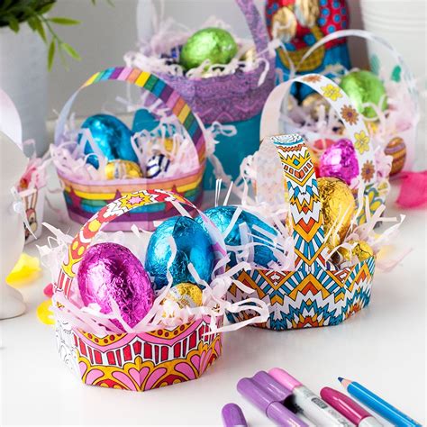 colorful easter baskets filled with chocolate eggs on a white table ...