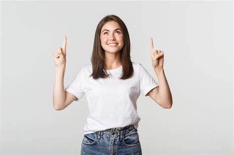 Free Photo Attractive Smiling Brunette Girl Pointing Fingers Up Showing Logo