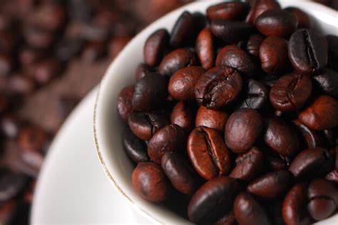 Premium Photo Dark Roasted Coffee Beans In White Cup With Blurred