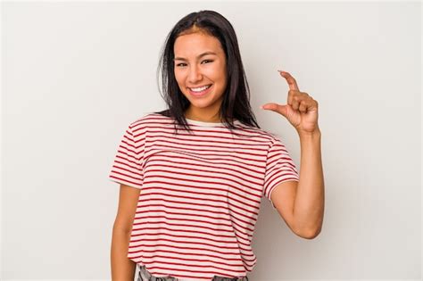 Mujer Latina Joven Aislada Sobre Fondo Blanco Sosteniendo Algo Poco Con Los Dedos Ndices