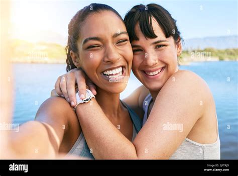 Portrait Of Two Smiling Friends Taking Selfies Together For Social