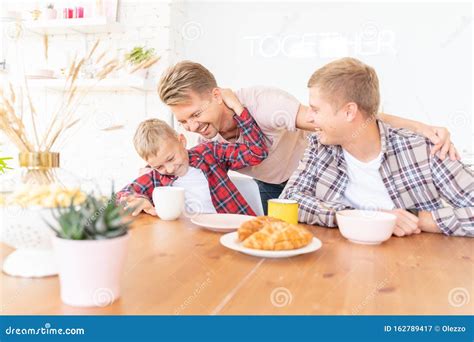 Felices Padres E Hijos Jóvenes Desayunan En La Cocina La Familia Gay Con Un Hijo Tiempo Juntos