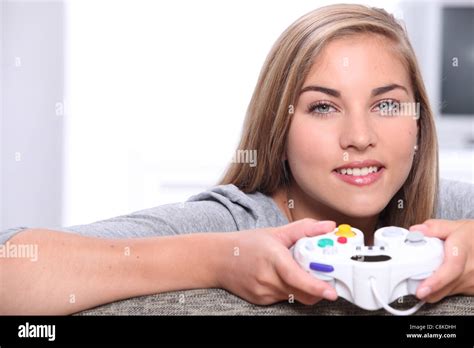 Jeune fille blonde à jouer à des jeux vidéo avec un tampon de contrôle Photo Stock Alamy