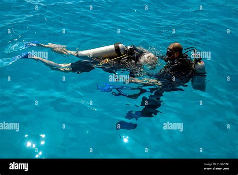 Learning Process Of Scuba Diving Experienced Instructor Teaches Beginner To Dive Into Sea Using