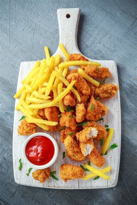 Fried Crispy Chicken Nuggets With French Fries And Ketchup On White