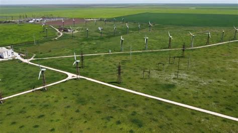 Wind Farms Near A Small Town Among The Green Fields Stock Footage