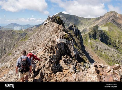 Hikers scrambling on Crib Goch ridge scramble at start of Snowdon