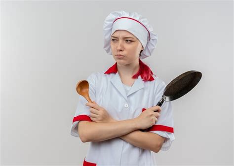 Jeune Femme Blonde Agacée Chef En Uniforme De Chef Croise Les Bras Et Détient Une Poêle Et Une