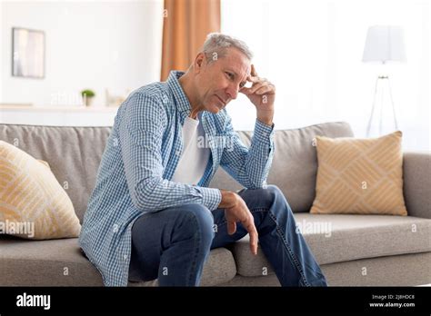 Upset Mature Man Sitting On Couch And Thinking Stock Photo Alamy