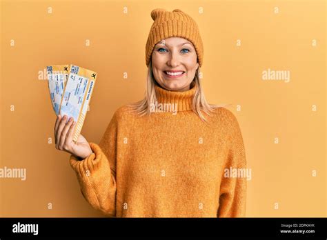 Belle femme blonde d âge moyen portant un chandail d hiver tenant l embarquement passez à l