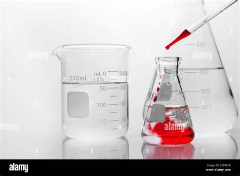 Red Drop Of Chemical Solution In Glass Flask In White Research Science