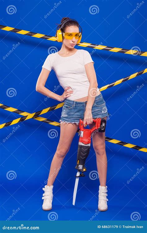 Brunette Builder On A Blue Background With An Electric Tool In The Hands Of Stock Image Image