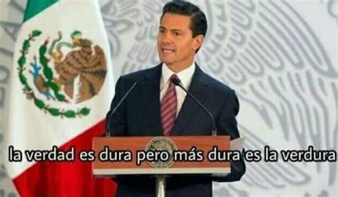 A Man In A Suit And Tie Standing At A Podium With Mexican Flags Behind Him