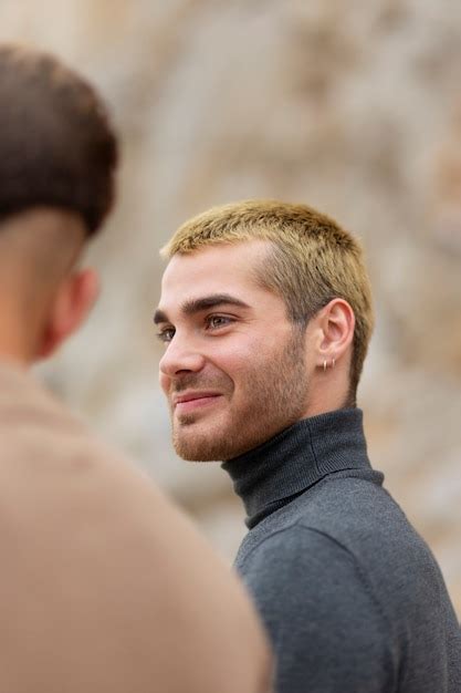 Una pareja gay siendo cariñosa y pasando tiempo juntos en la playa Foto Gratis