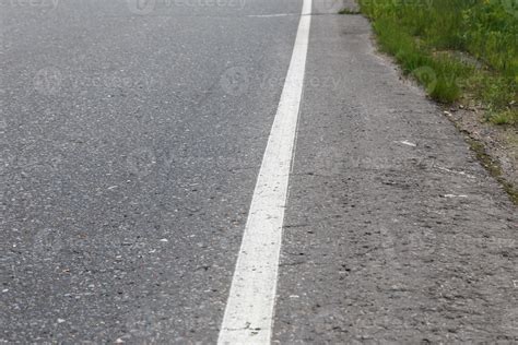 White solid line. Road marking on an asphalt road. selective focus