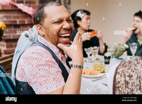Cheerful Gay Man Laughing While Enjoying During Party With Friends In Back Yard Stock Photo Alamy