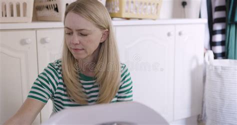 Mature Woman Washing Machine And Doing Laundry While Loading Clothes