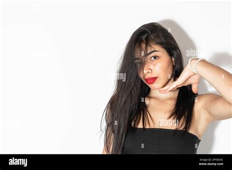 Beautiful Latina Woman With Brown Skin Posing On A White Background Showing Her Chin Stock
