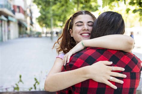 Happy Lesbian Couple Hugging Each Other On Footpath Stock Photo