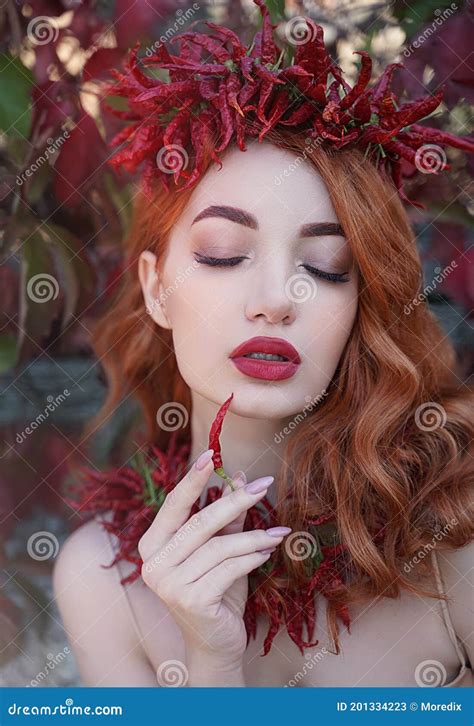 Portrait Of A Red Haired Sexy Woman With Red Full Lips In A Crown And A Necklace Of Hot Chili
