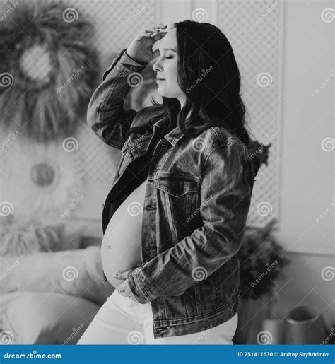 Black And White A Beautiful Pregnant Woman In A Denim Jacket With A Naked Tummy Stock Photo