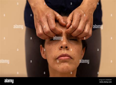 Latina Woman Receiving An Ayurvedic Massage On The Face With Specific Pressure Points Stock