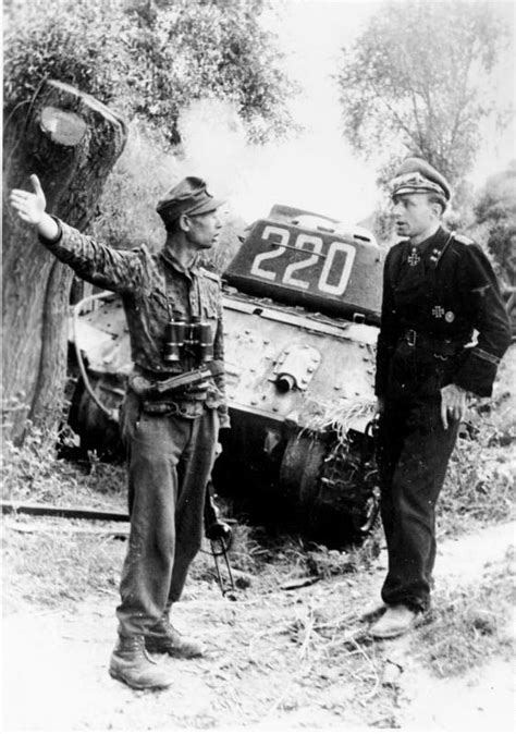 Troops of the 12th SS Panzer Division Hitlerjugend rest near a knocked ...