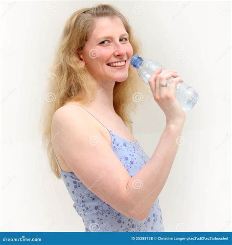 Het Meisje Van De Blonde Glimlacht Terwijl Het Nemen Van Een Drank Van Water Stock Foto Image