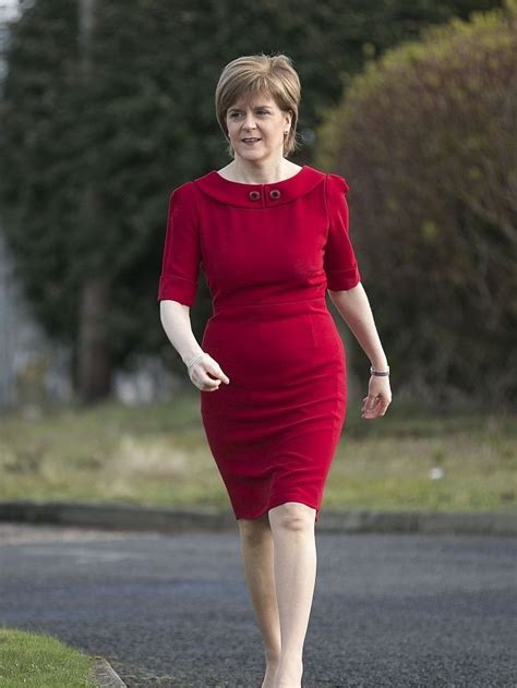 A Woman In A Red Dress Is Walking Down The Street